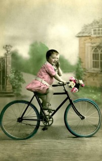 Girl's bicycle, 1910s, Little boy in pink clothes sitting on a bicycle with flower decoration,