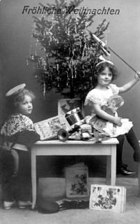 Boy and girl under a Christmas tree, 1930s, Two children sitting in front of a Christmas tree with