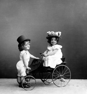 Two children with tricycle, 1920s, Two children in Victorian costumes playing on an antique