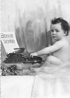 Baby writing at a typewriter, 1920s, A baby sits next to a typewriter with a French greeting,
