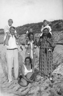 Family on the beach, 1920s, family photo on the beach with adults and children, children sitting on