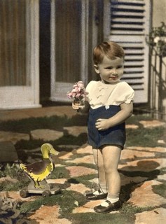 Little boy, 1930s, Boy with plush duck and bouquet of flowers in front of a front door, historical