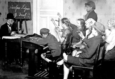 Young people playing school, ca. 1920, children in the classroom writing with pencils while the