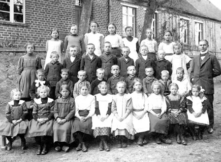School class with teacher, 1920s, Group photo of a school class with teacher in front of a brick