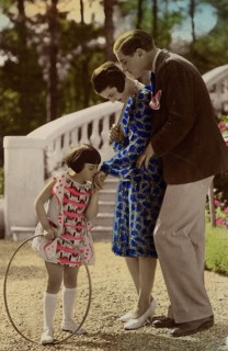 Girl kissing woman's hand, 1920s, child with a ring playing happily, watched by parents in the