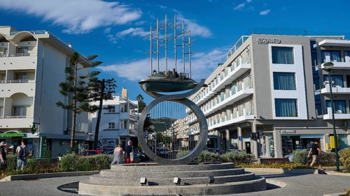 Modern sculpture in an urban setting with surrounding modern buildings, Sculpture The Traveller,
