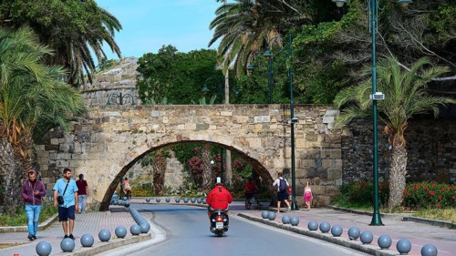 Street scene with arched bridge and people under palm trees along the road, Bridge, Neratzia