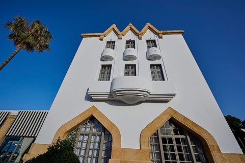 Modern white building with balconies and palm trees, clear, sunny atmosphere, Boutique Hotel
