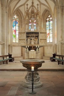 High altar and baptismal font of the Romanesque St. Mary's Church, interior view, colourful church