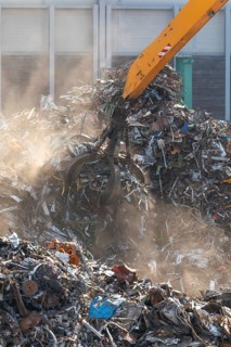 Hydraulic crane lifts scrap metal at the scrap yard