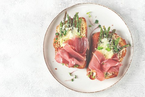 Open sandwiches with asparagus and prosciutto, with cheese, breakfast, on a plate