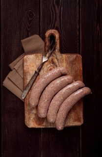 Raw sausages in English with bacon, for grilling, on a cutting board, top view, no people