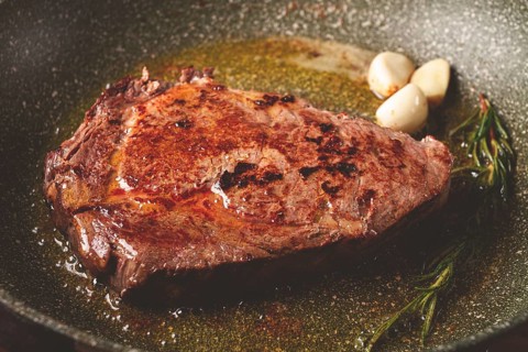 Fried steak, beef steak, rib eye steak, in a frying pan, top view, no people