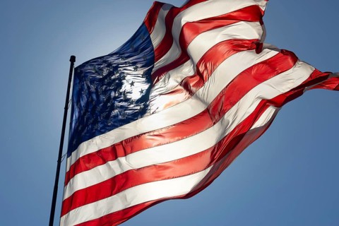 Dramatic backlit american flag waving in the wind