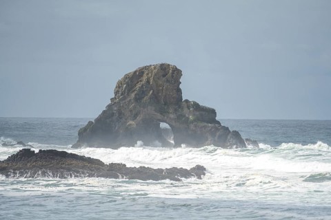 A rugged coastal landscape with rocks in the sea and a cloudy sky, Indian Beach, Oregon, USA, North