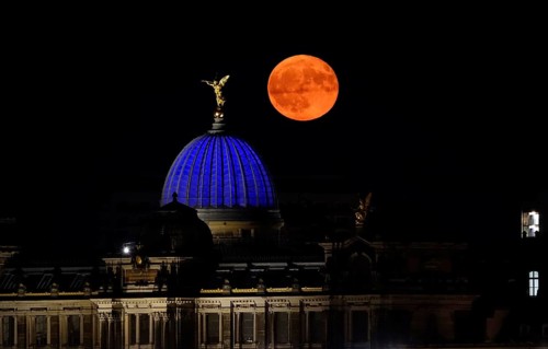 Glowing strawberry moon on 11 June 2025 over the Dresden University of the Arts, Saxony, Germany