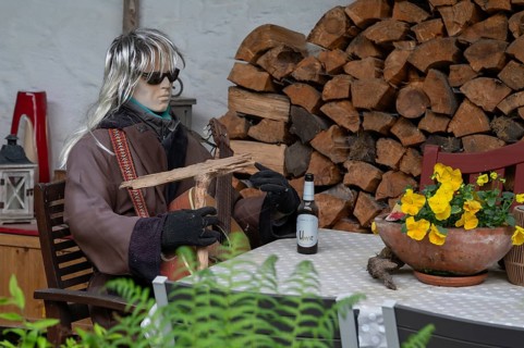 Sitting mannequin at a garden table, Bavaria, Germany