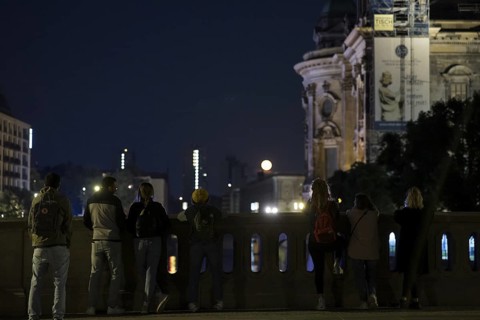 People watching the rising moon from the Friedrichsbrücke bridge next to Berlin Cathedral, Berlin,