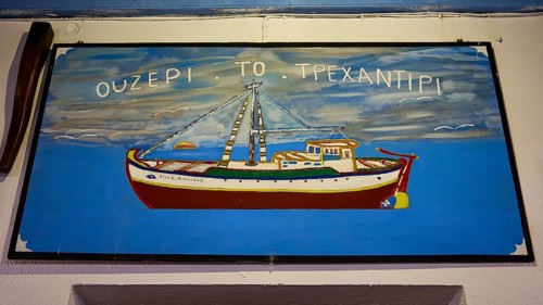 Blue sign with an illustrated boat and lettering, Skala, harbour, Ouzerie Tavern Trehantiri,
