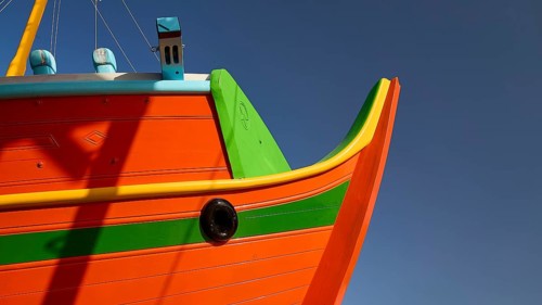 Close-up of the boat bow with orange and green paint, Diakofti boatyard, new construction of a