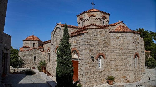 Large stone church building with several domes and a cross in the courtyard, woman's monastery,