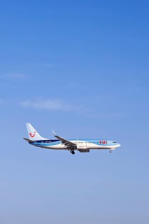 Passenger plane from Tui travel company flying on a blue sky, Mallorca, Spain