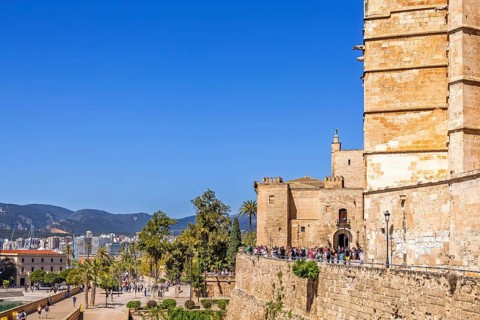 View at Palma city with tourists in the sunshine outside the famous old Palma Cathedral, Palma de