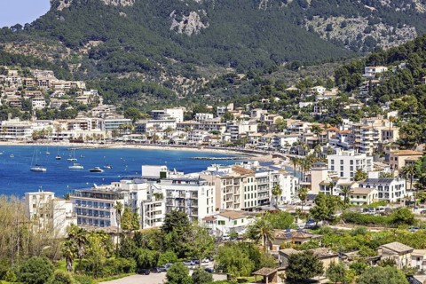 View at a tourist resort with houses by a seabay and mountains in the summer, Sant Elm, Mallorca,