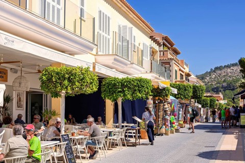 Outdoors restaurant on a street with tourist sitting in the sunshine in an idyllic village, Sant