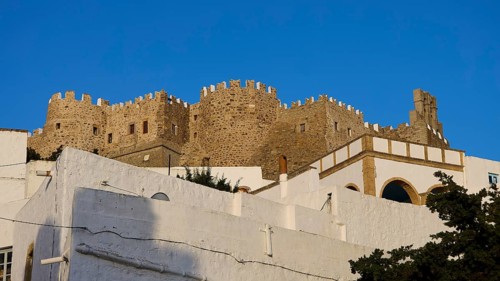 Majestic, historic castle above white buildings under a blue sky, Monastery of St John the