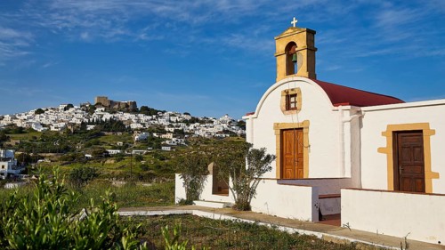 White chapel with a view of a village under a blue sky, chapel south of the Chora, World Heritage