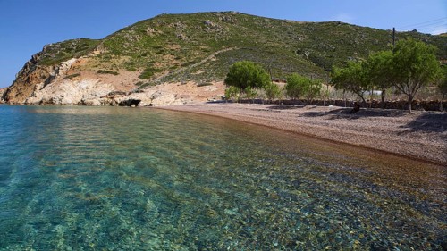 Quiet beach with green hill in the background and clear blue water, Lambi Beach, Lambi Bay, Patmos,