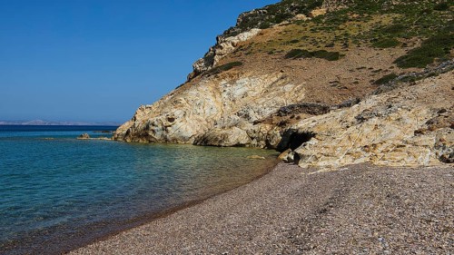 Stone beach under clear blue sky with coastline and water, Lambi Beach, Lambi Bay, Patmos,