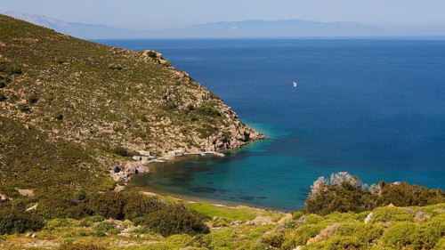 Sweeping views of turquoise blue sea and green hills with a narrow stretch of coastline,