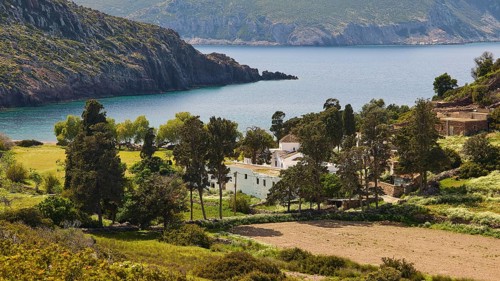Small village on a rocky coast, surrounded by trees and blue sea, Limoni Kalogiron Monastery,