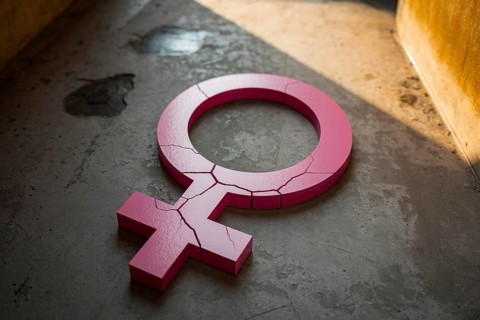 Cracked pink female gender symbol on concrete floor representing femicide. Generative Ai, AI