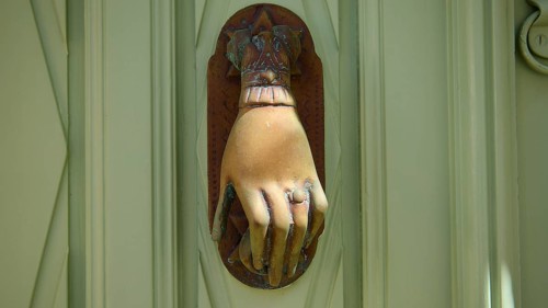 Detail of an ancient, hand-shaped door knocker on a green door, Chora, UNESCO World Heritage Site
