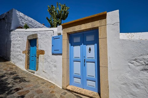 Residential houses with blue doors and cactus in the front garden, traditional Mediterranean