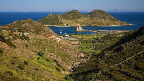 Hilly landscape with fields and coast, green and blue dominate the view, rocks of Kalikatsou,