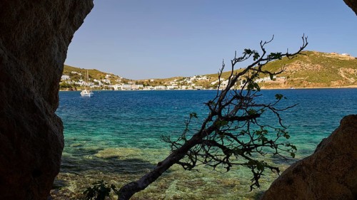 View through a rock opening over the blue sea and the coastal town, Cave, Grikos, Rock of