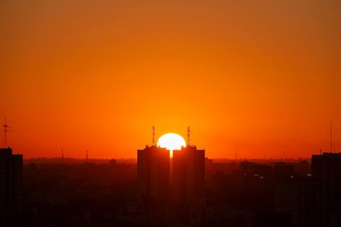 Sunset over skyscrapers in Buenos Aires, symmetry in photography, symbolic image for heat, global