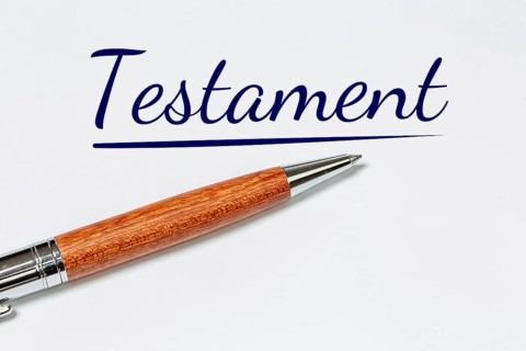 Symbolic image of a will: biros on a white sheet with added text TESTAMENT