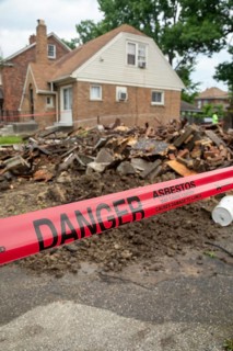 Detroit, Michigan - Signs warn of asbestos danger where a house was demolished. The house had been