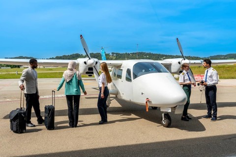 Pilots and passengers engaging in preparations for an upcoming flight on a small airplane at a