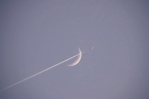 Evening sky with crescent moon and aeroplane, Germany