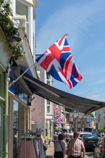 Union Jack flags on shops in street of historic buildings, The Strand, Dawlish, south Devon,