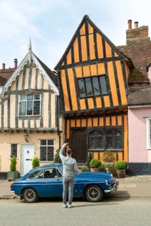 Person taking phone photo of The Crooked House, Lavenham, Suffolk, England, UK