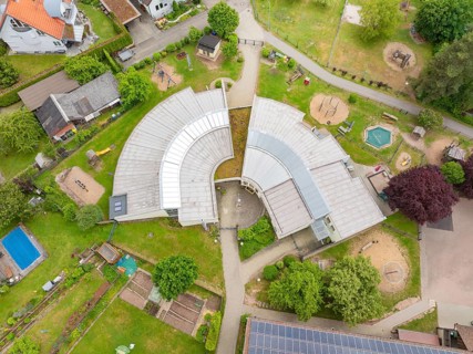 Building complex with an innovative architectural design and surrounding play and green areas,