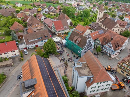Aerial view of a small village with traditional buildings and a central church with surrounding