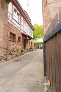 Narrow alley with traditional half-timbered houses and stone walls in a historic neighbourhood,